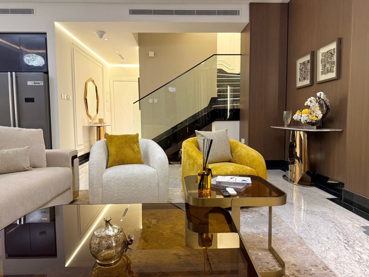 Living area of a completed Montroyal project — bespoke furnishing, marble flooring and a glass staircase
