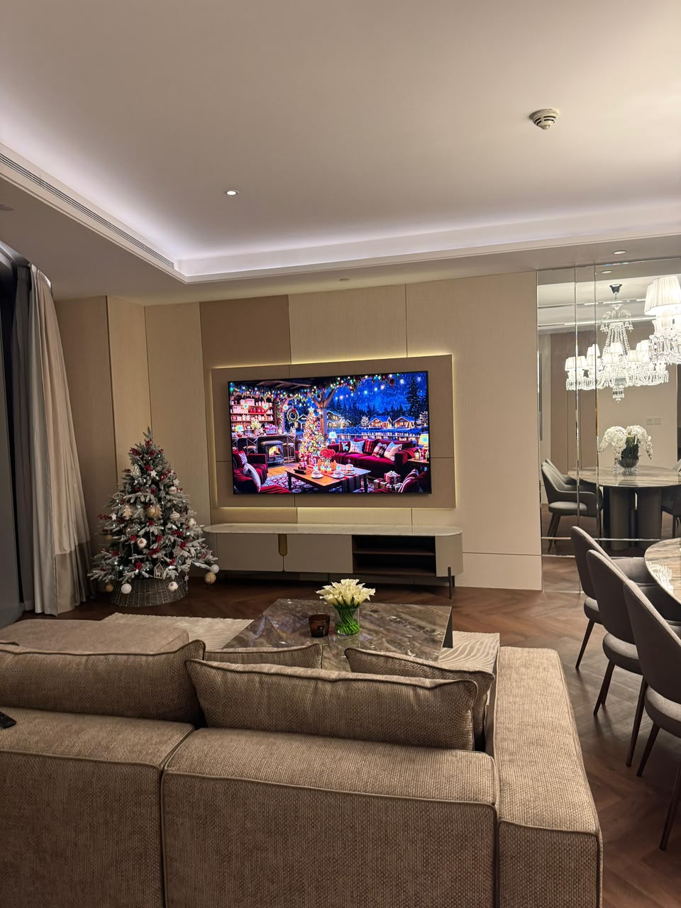 The same living area after renovation, with upholstered panelling and herringbone flooring