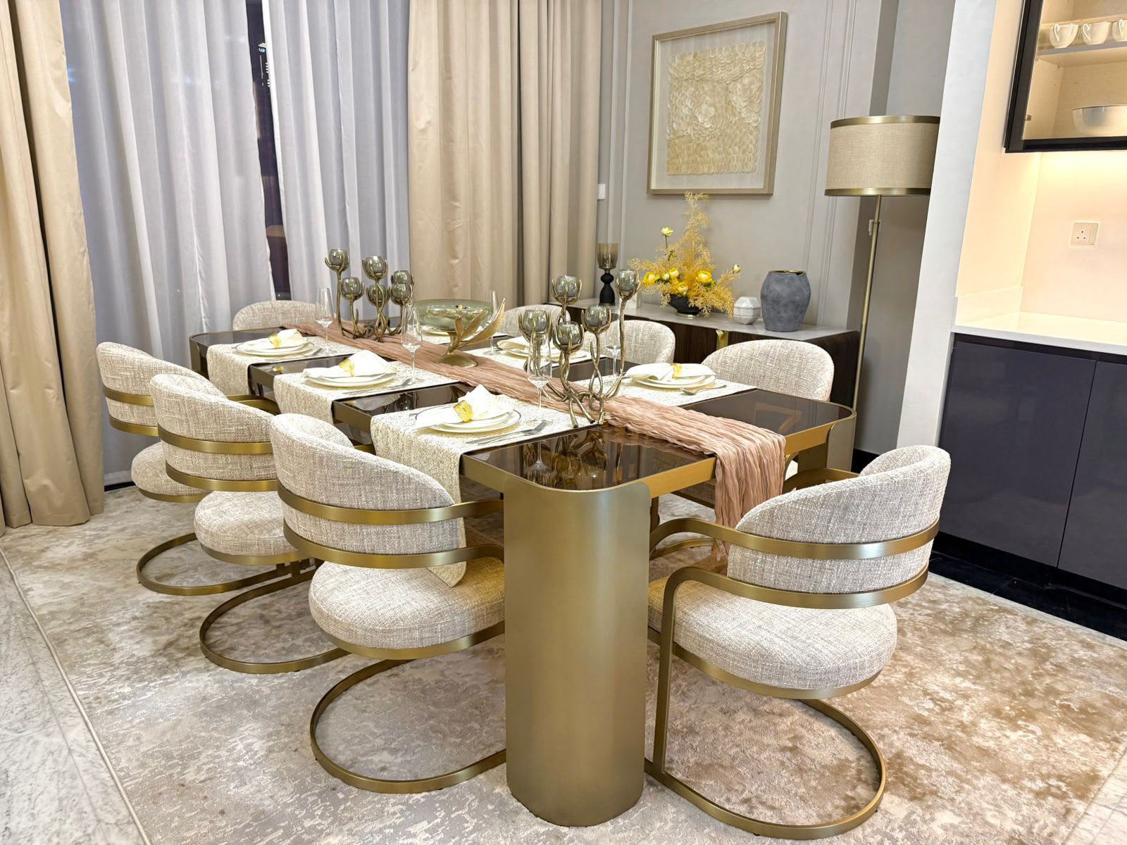 A completed Montroyal dining room — brushed gold table, bouclé seating and layered lighting